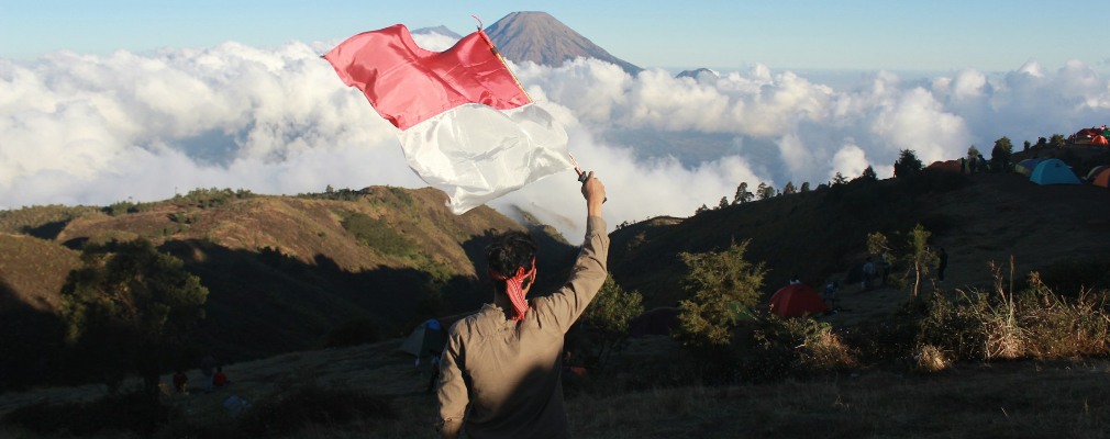 Man zwaait met Indonesische vlag in de bergen